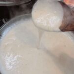 Homemade gravy on a spoon showing consistency