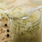 Homemade sauerkraut in a glass mason jar on a fork